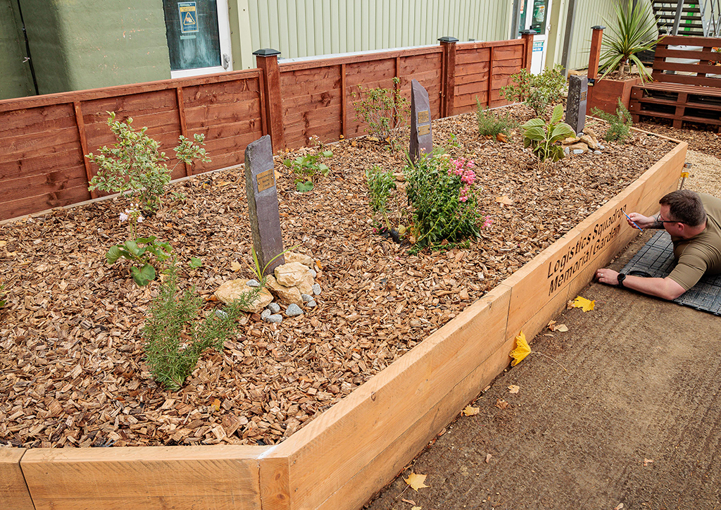 Viewing the raised bed and planting. The bed also contains several memorial stones with plaques.